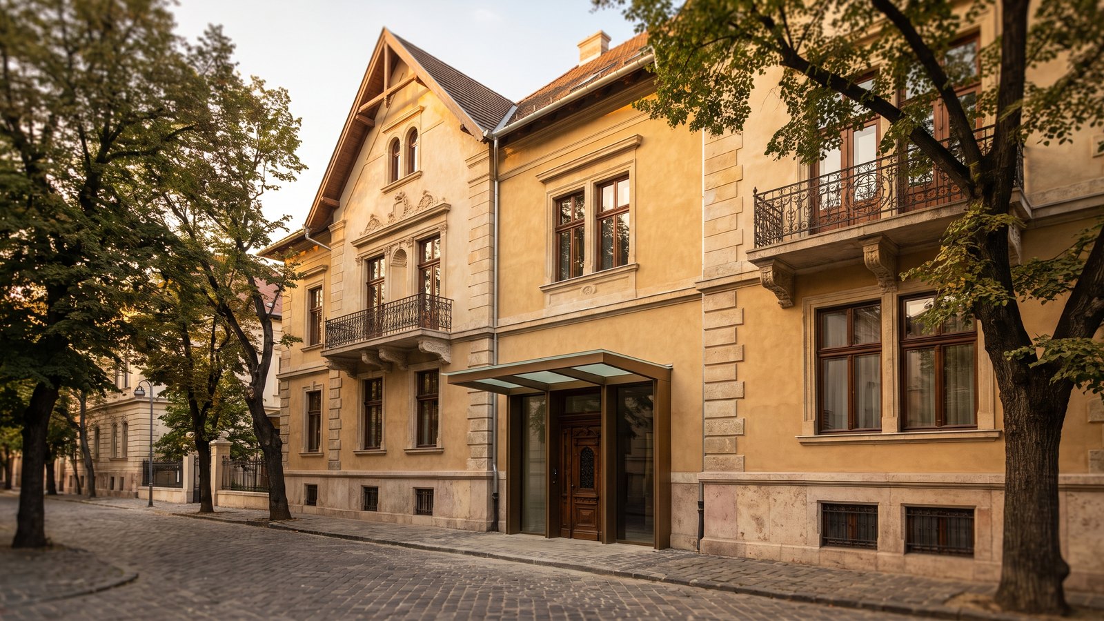 Gondosan felújított historizáló villa homlokzata a budai Várnegyed macskaköves utcájában, alkonyi fényben
