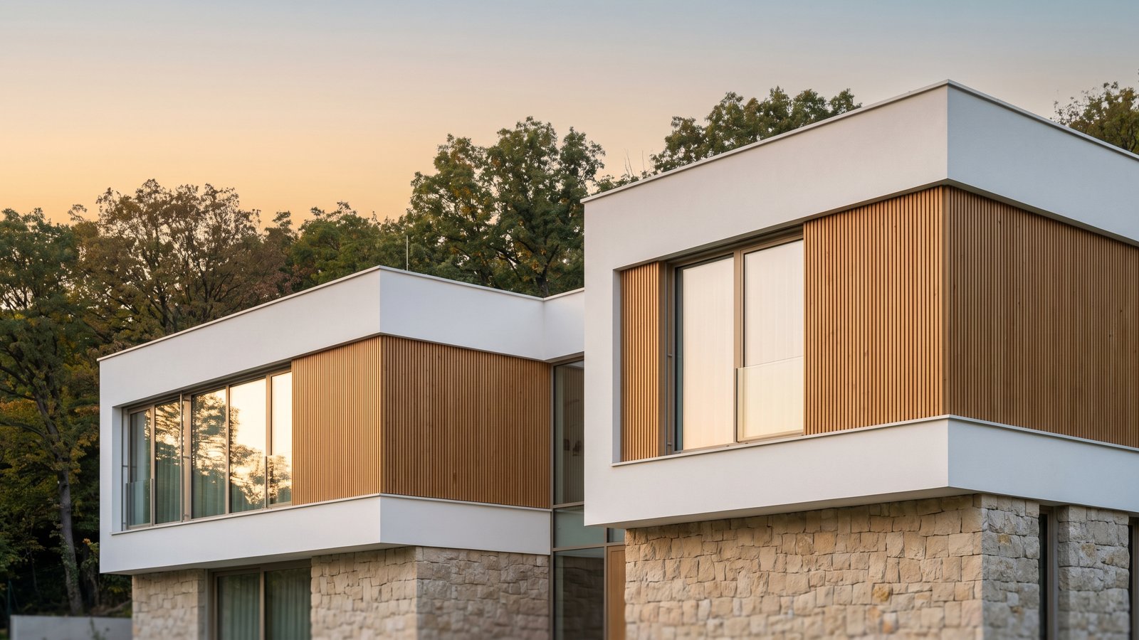 Kortárs prémium villa homlokzata a budai agglomerációban, precíz anyagcsatlakozásokkal, alkonyi fényben