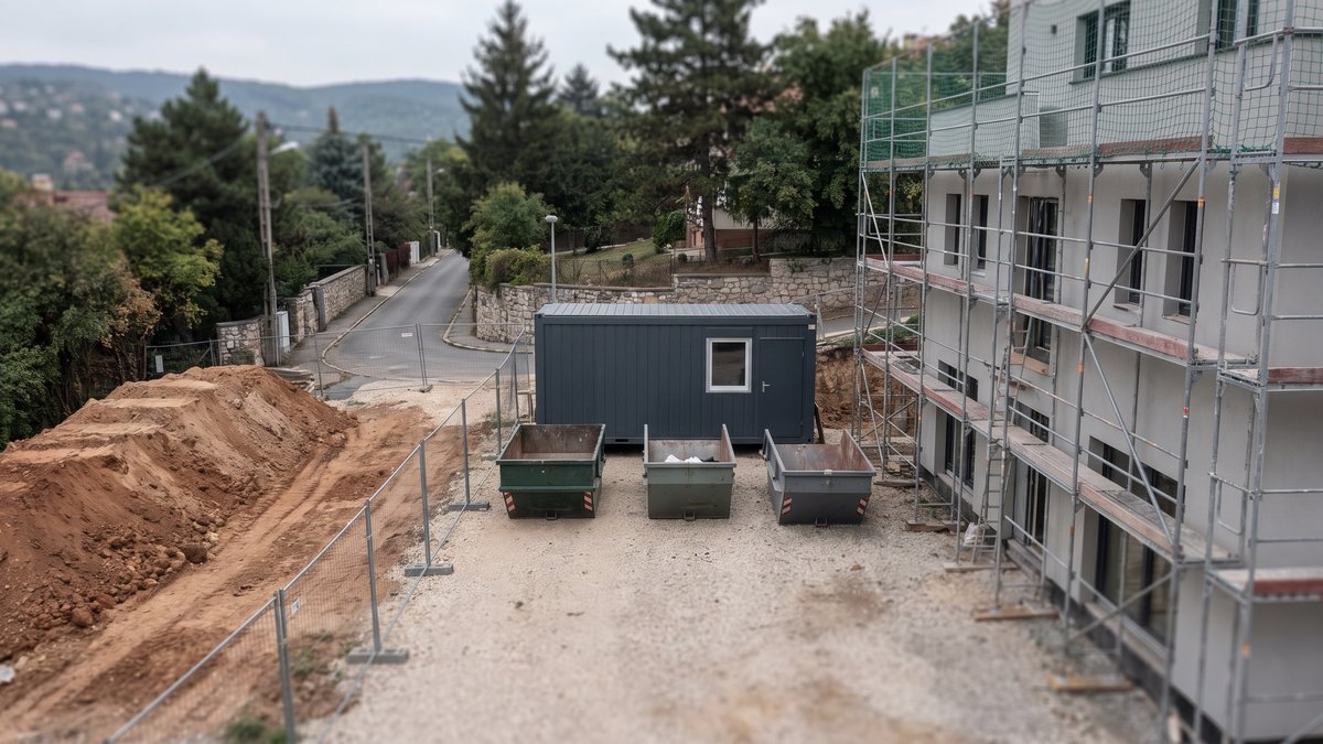Rendezett építési felvonulási terület: állvány, irodakonténer, hulladékkonténerek és deponált föld egy budai hegyoldali telken